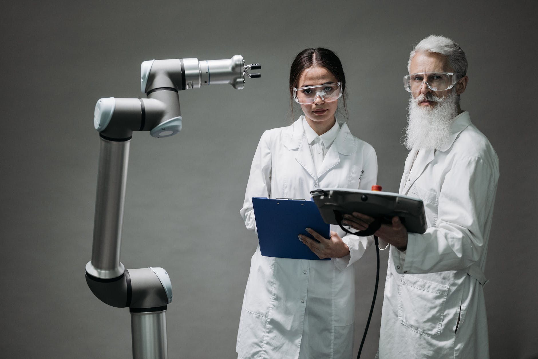 Robot and two researchers with clipboards and white coats.