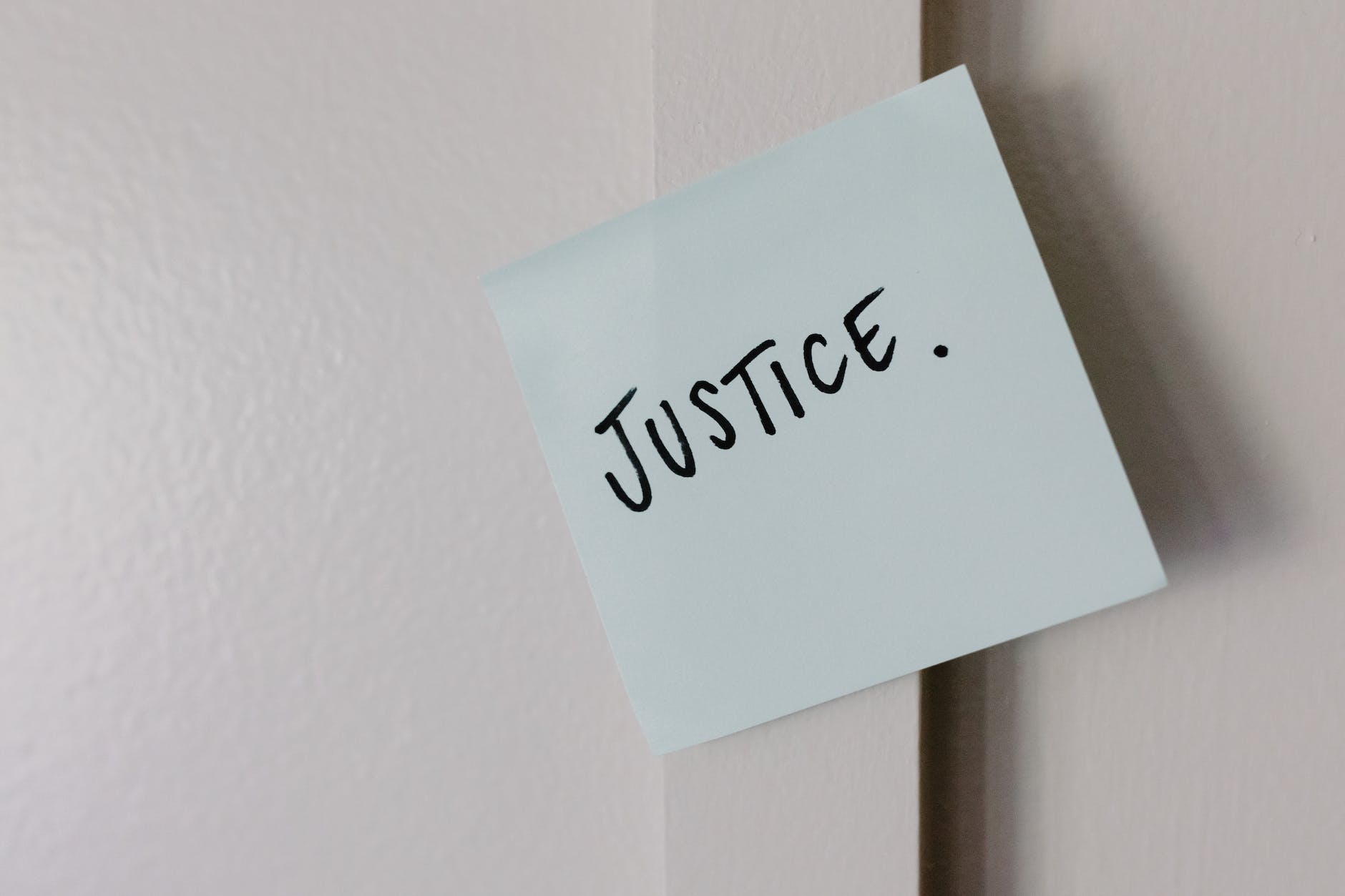 white sticky note with the word justice