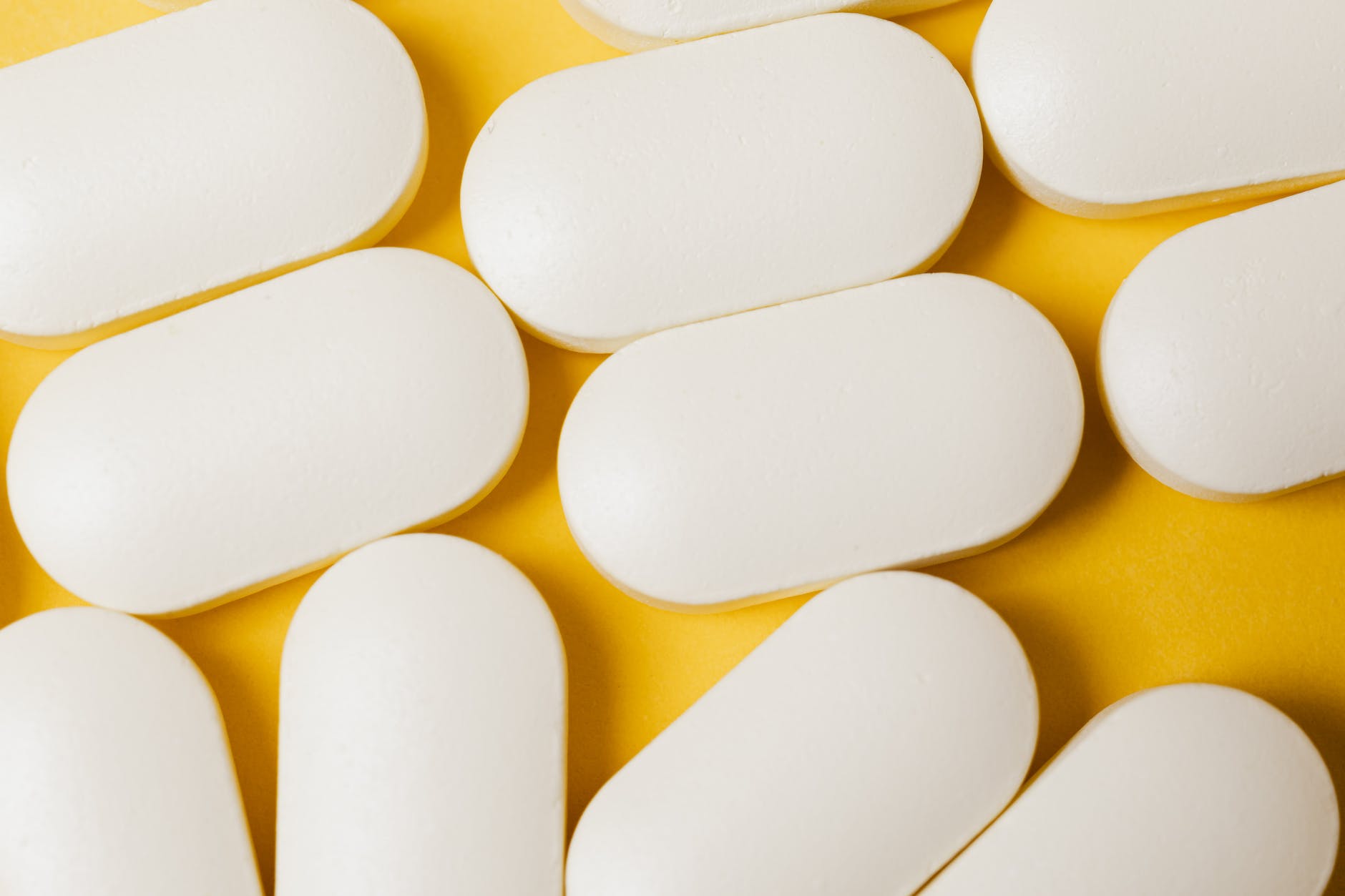 white capsules/pills on yellow background