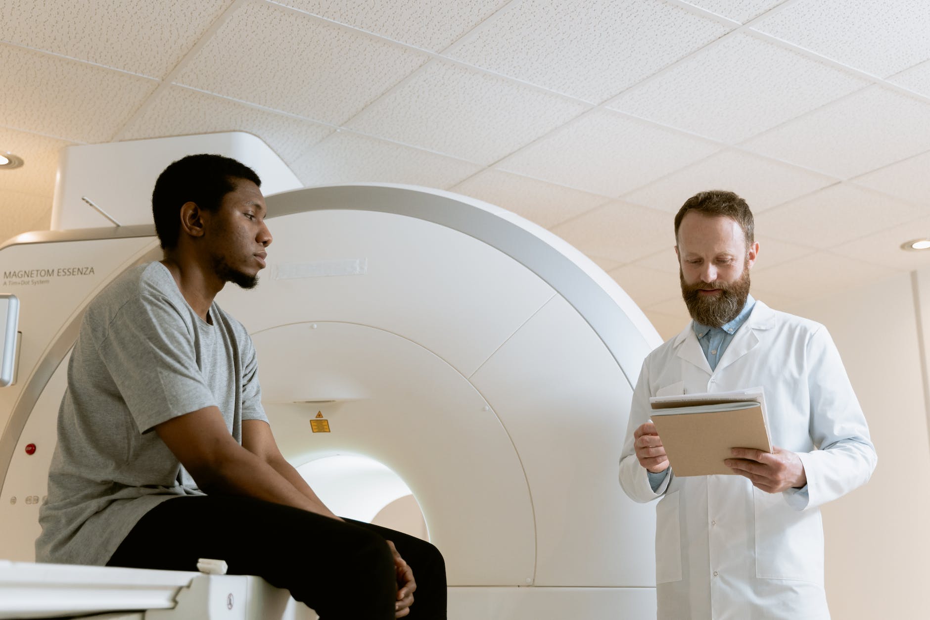 Radiation technologist helping patient prepare for CT scan.