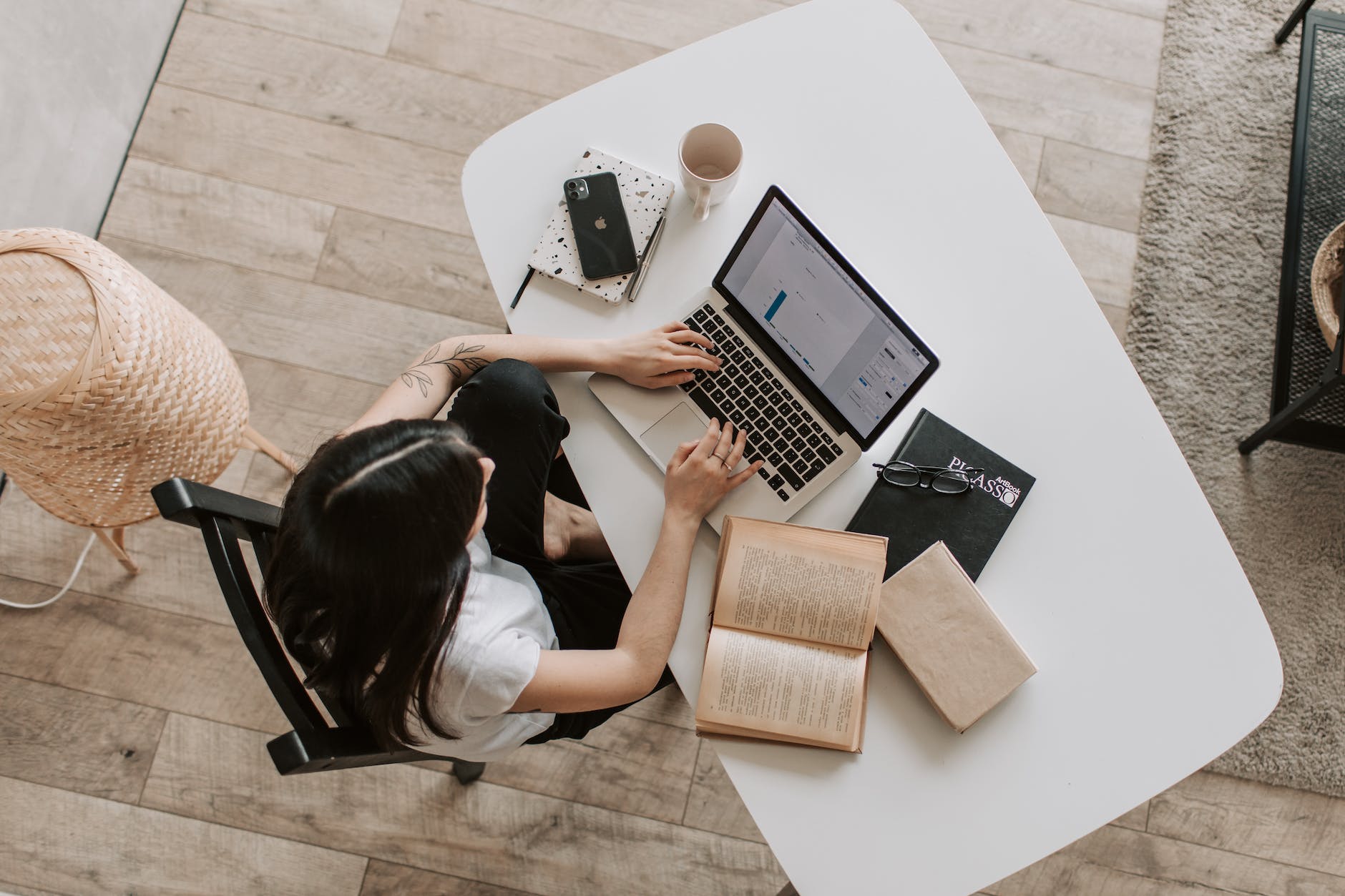 woman typing on keyboard of laptop in living room