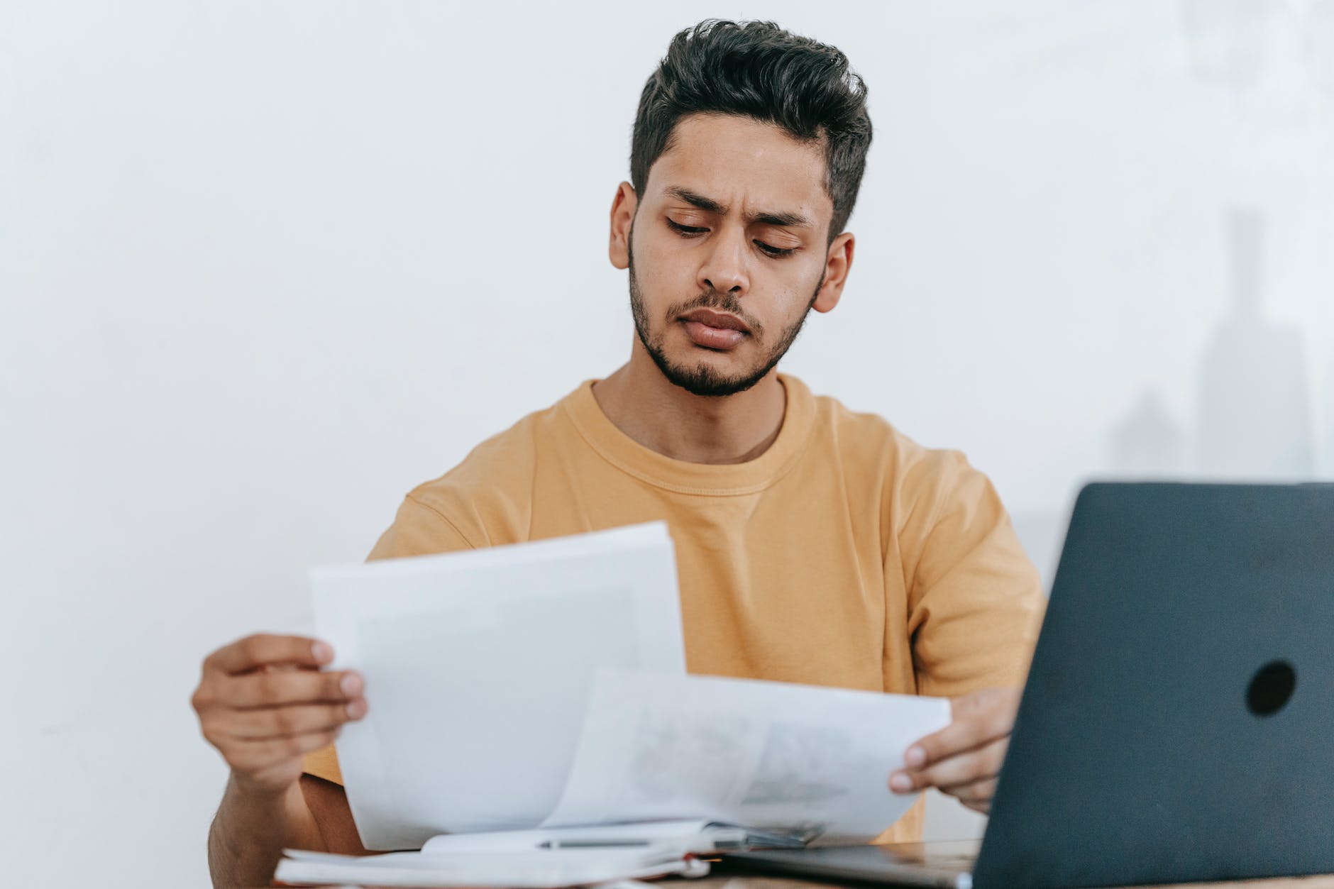 man looking through documents and workspace