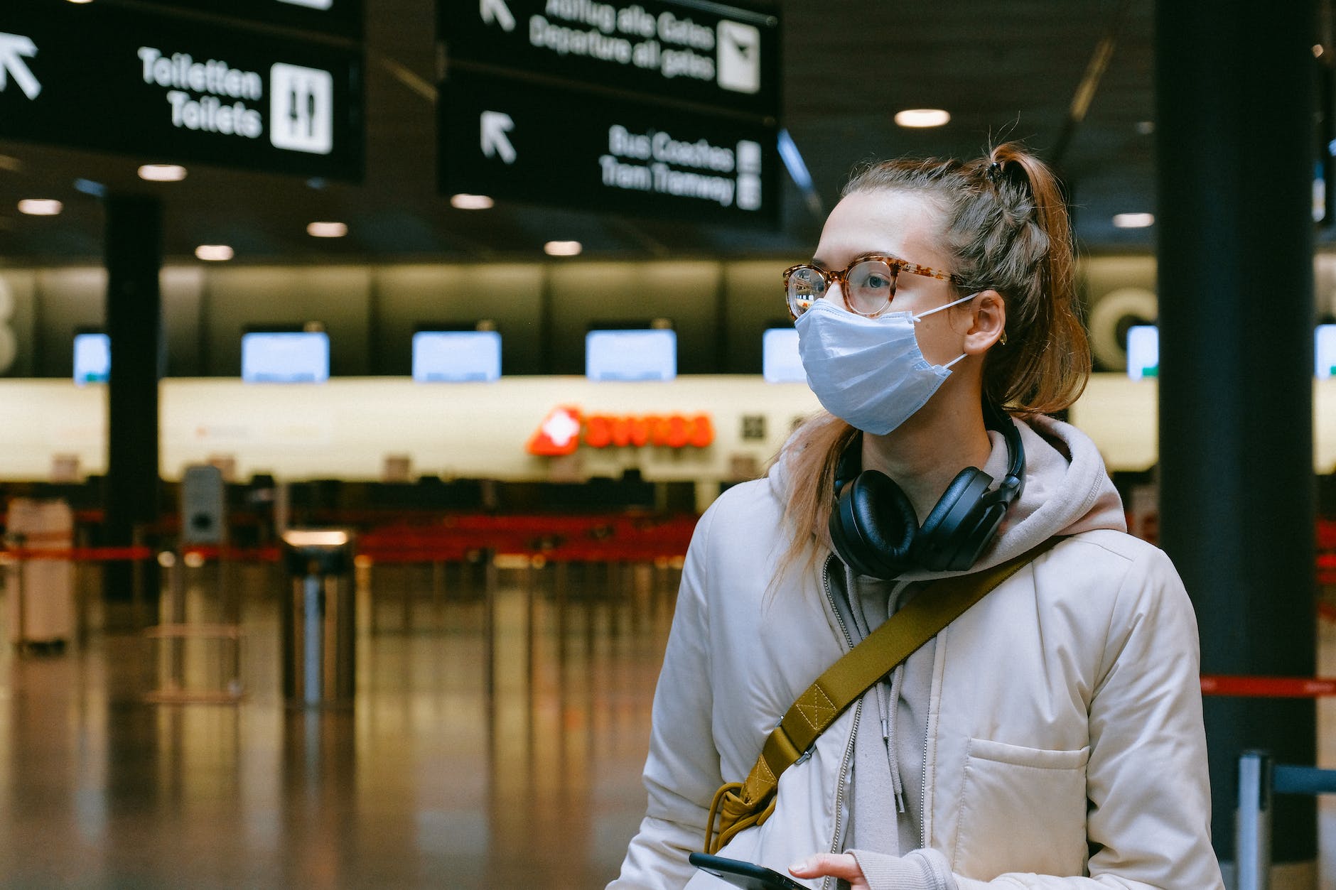 Woman wearing mask and headphones at airport