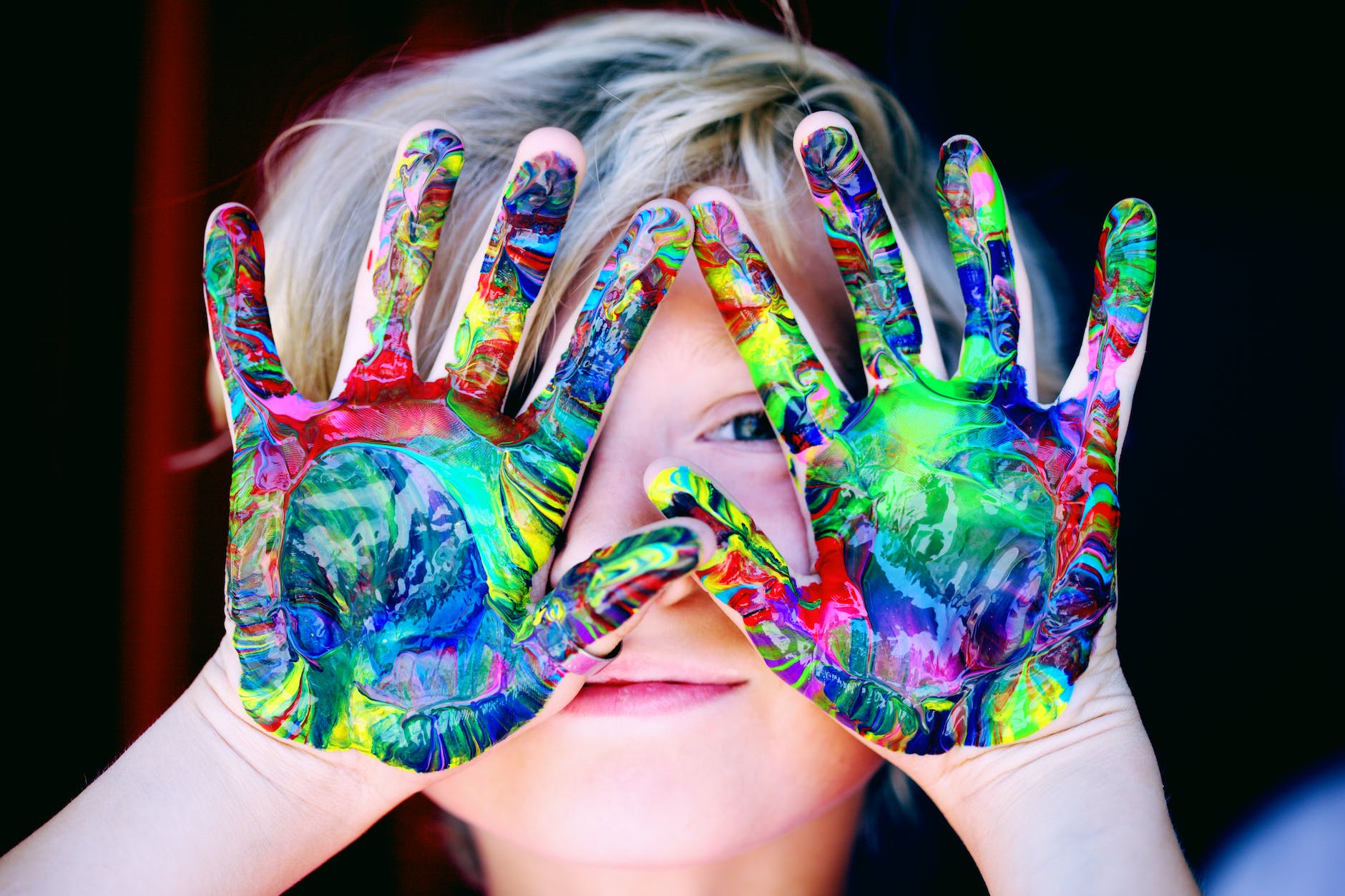 A child with multicolored hand paint