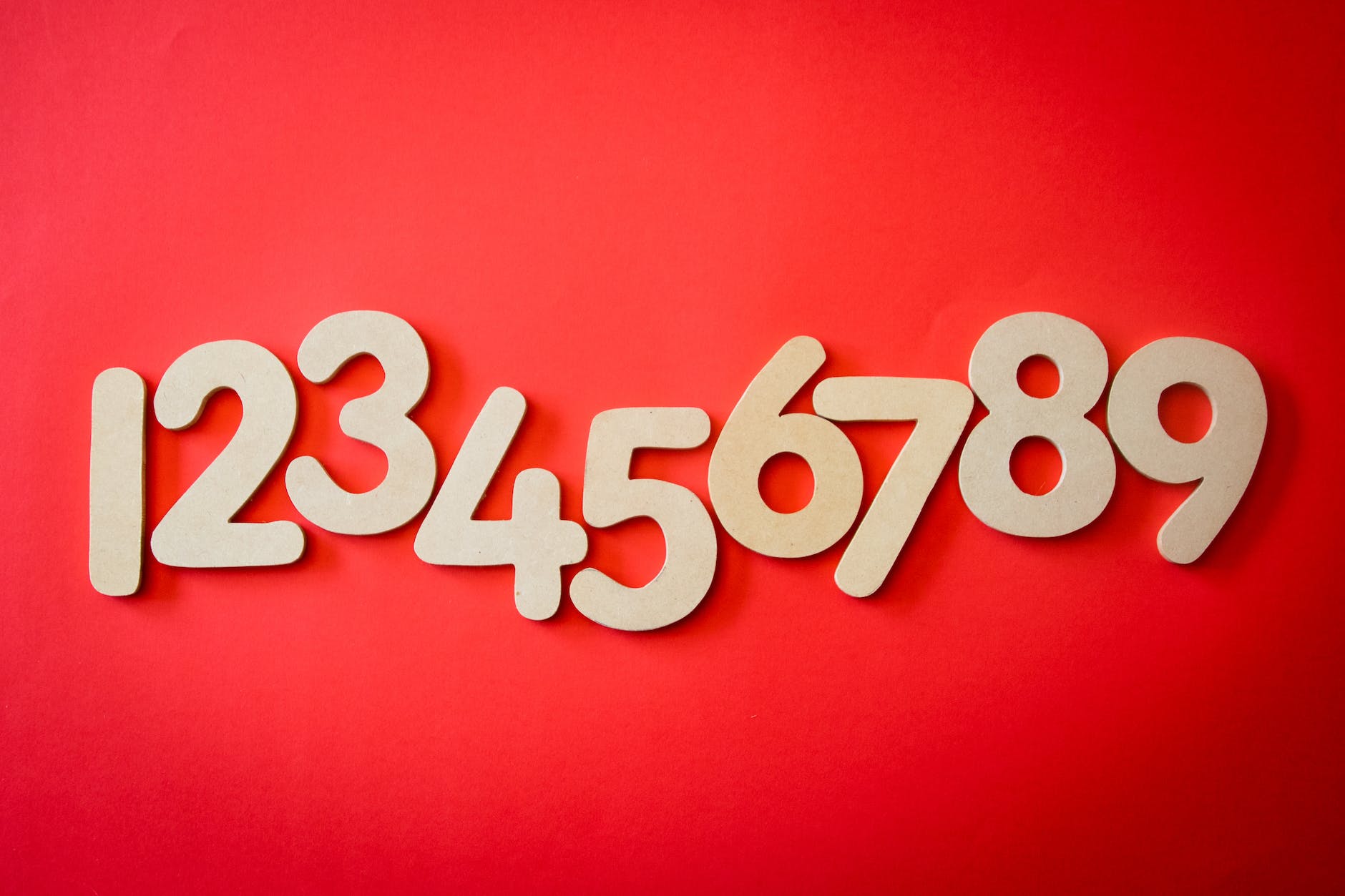 Red background with numbers from 1 to 9 in beige/wood.