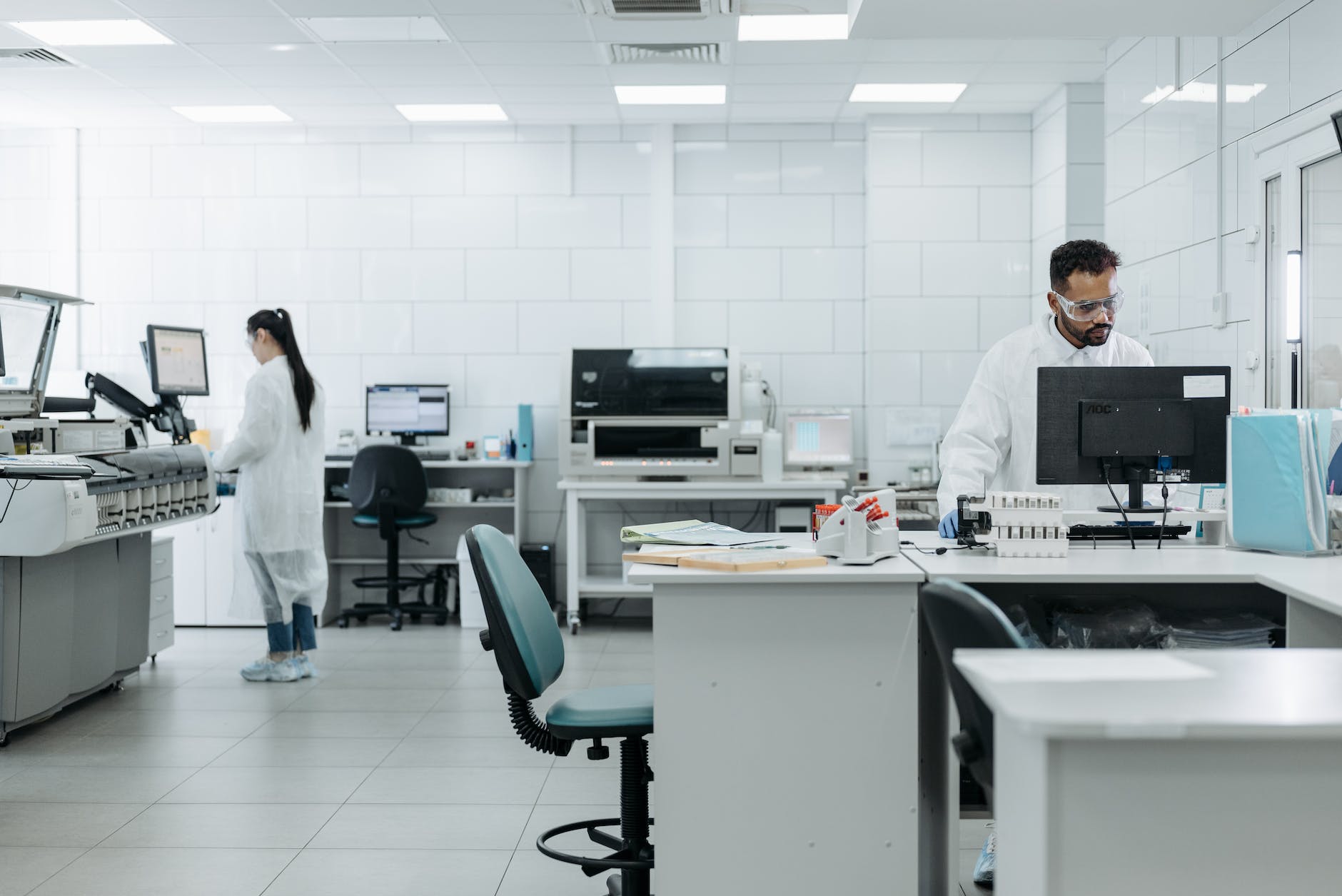 a man and a woman in a lab with several instruments and automation