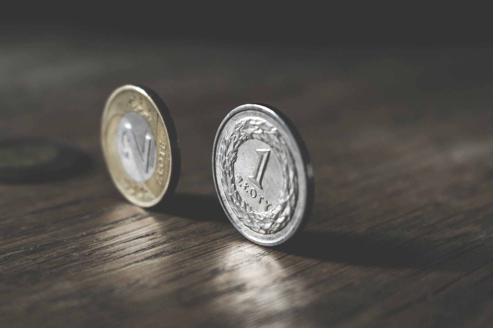 two gold-colored and silver-colored coins standing on floor