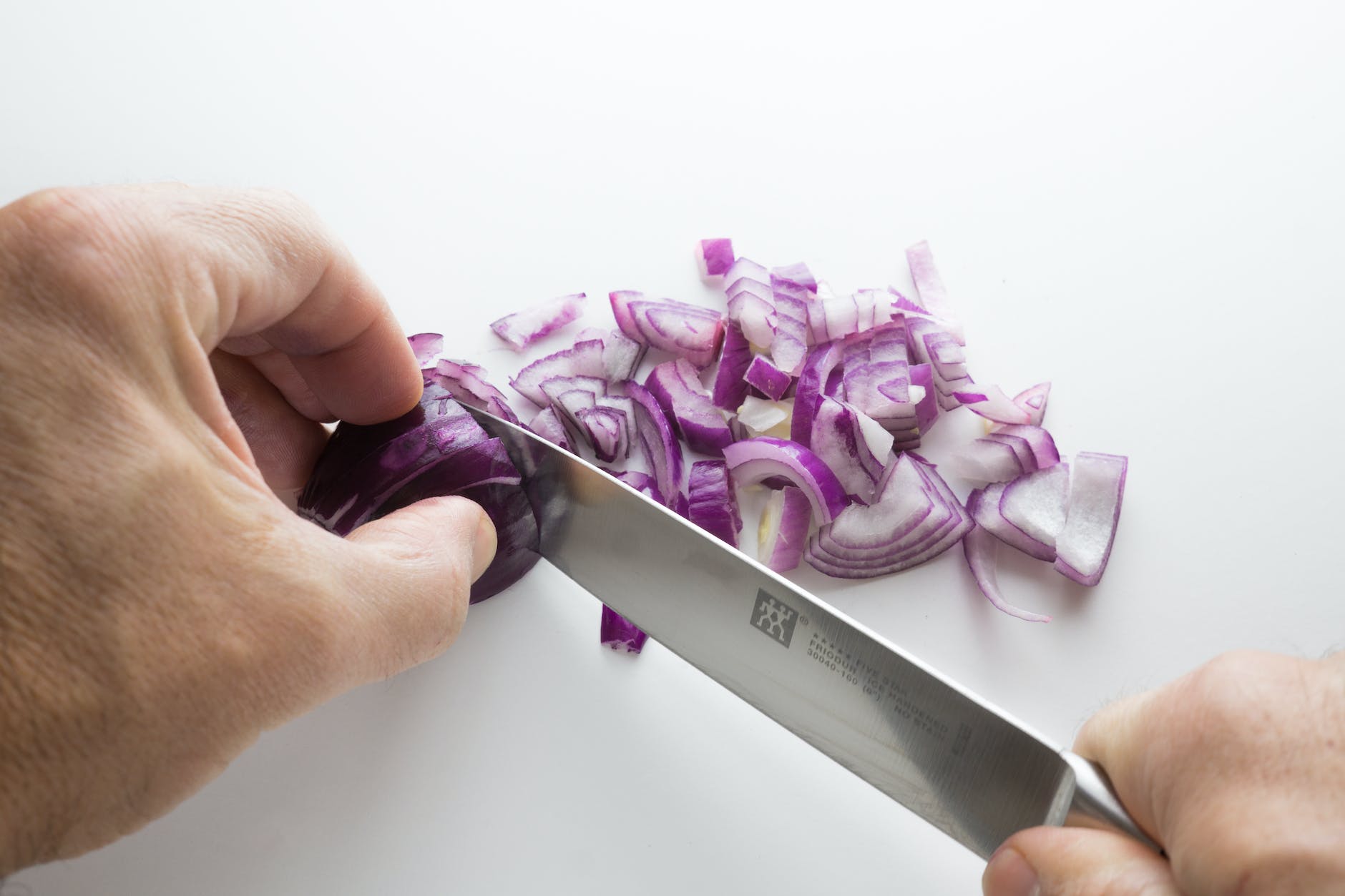 person chopping onion with knife