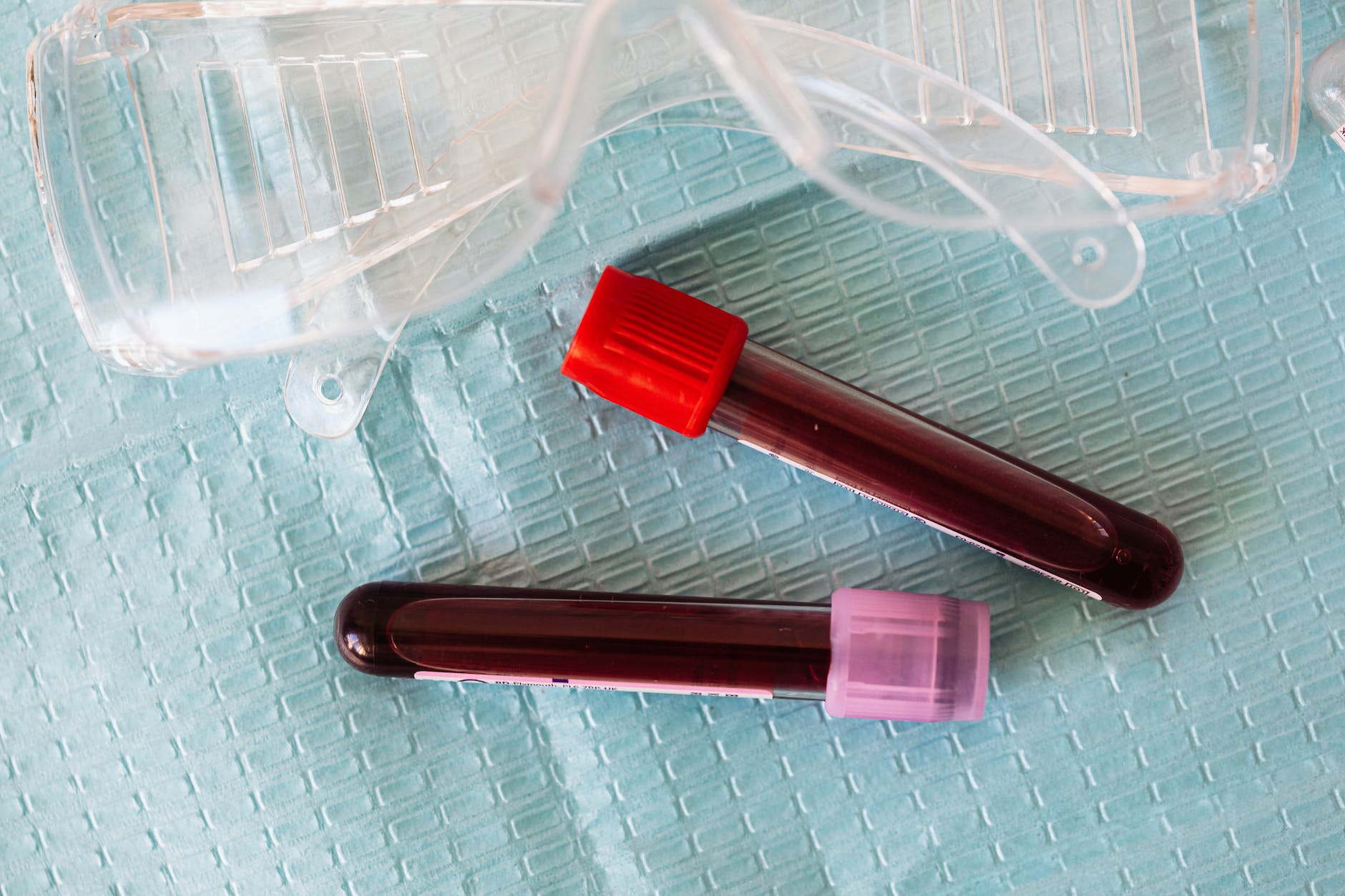 medical eyeglasses and two vials of blood.