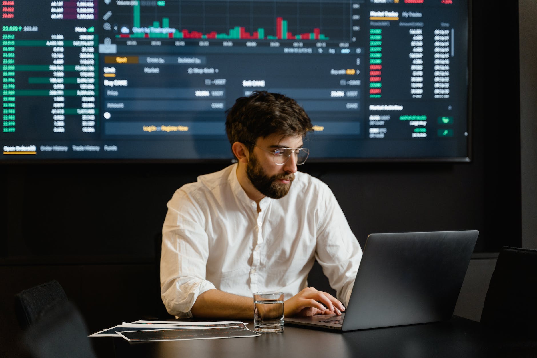 man in white dress shirt using laptop and surrounded by data