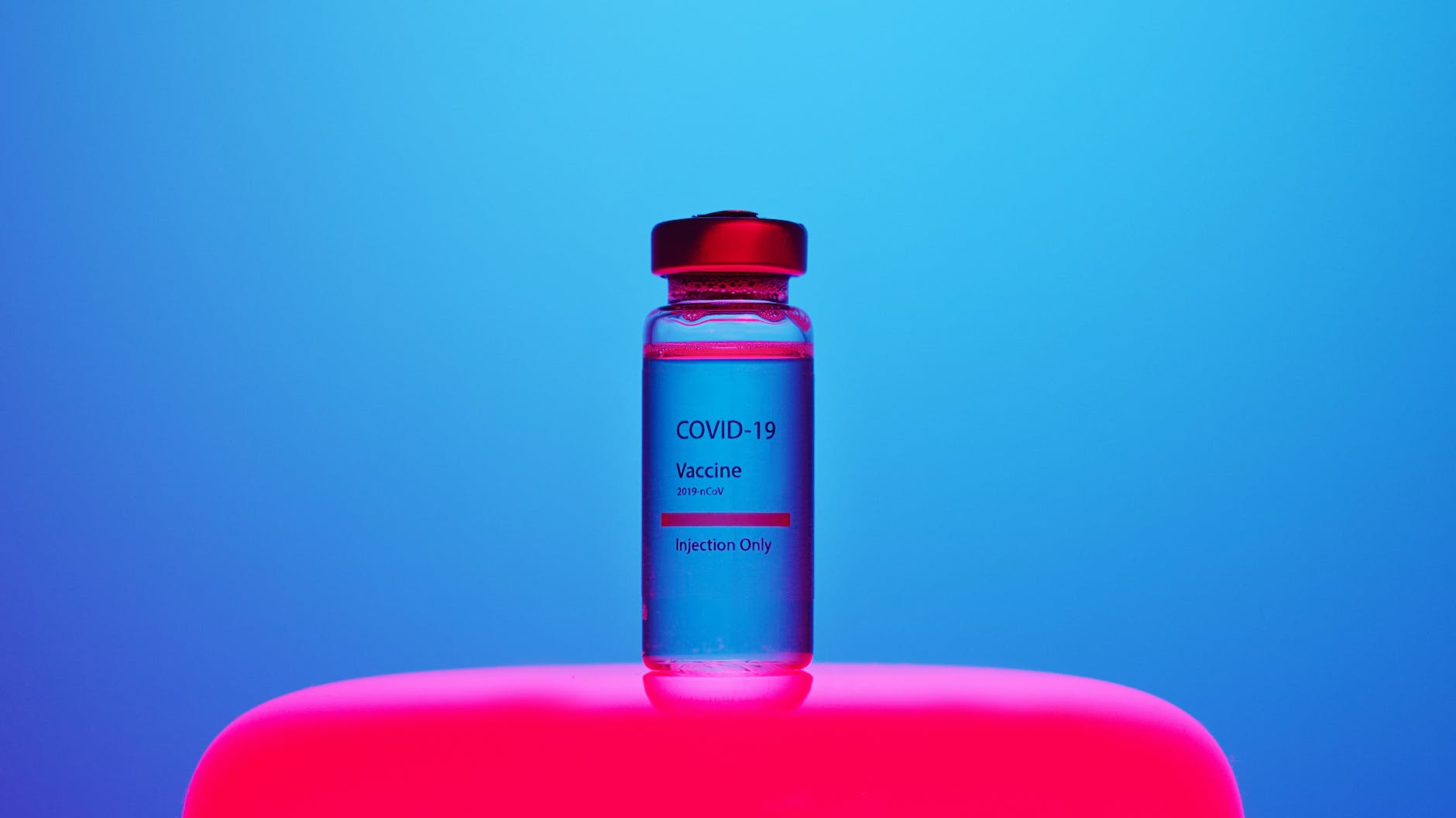 a COVID-19 vaccine vial on blue background