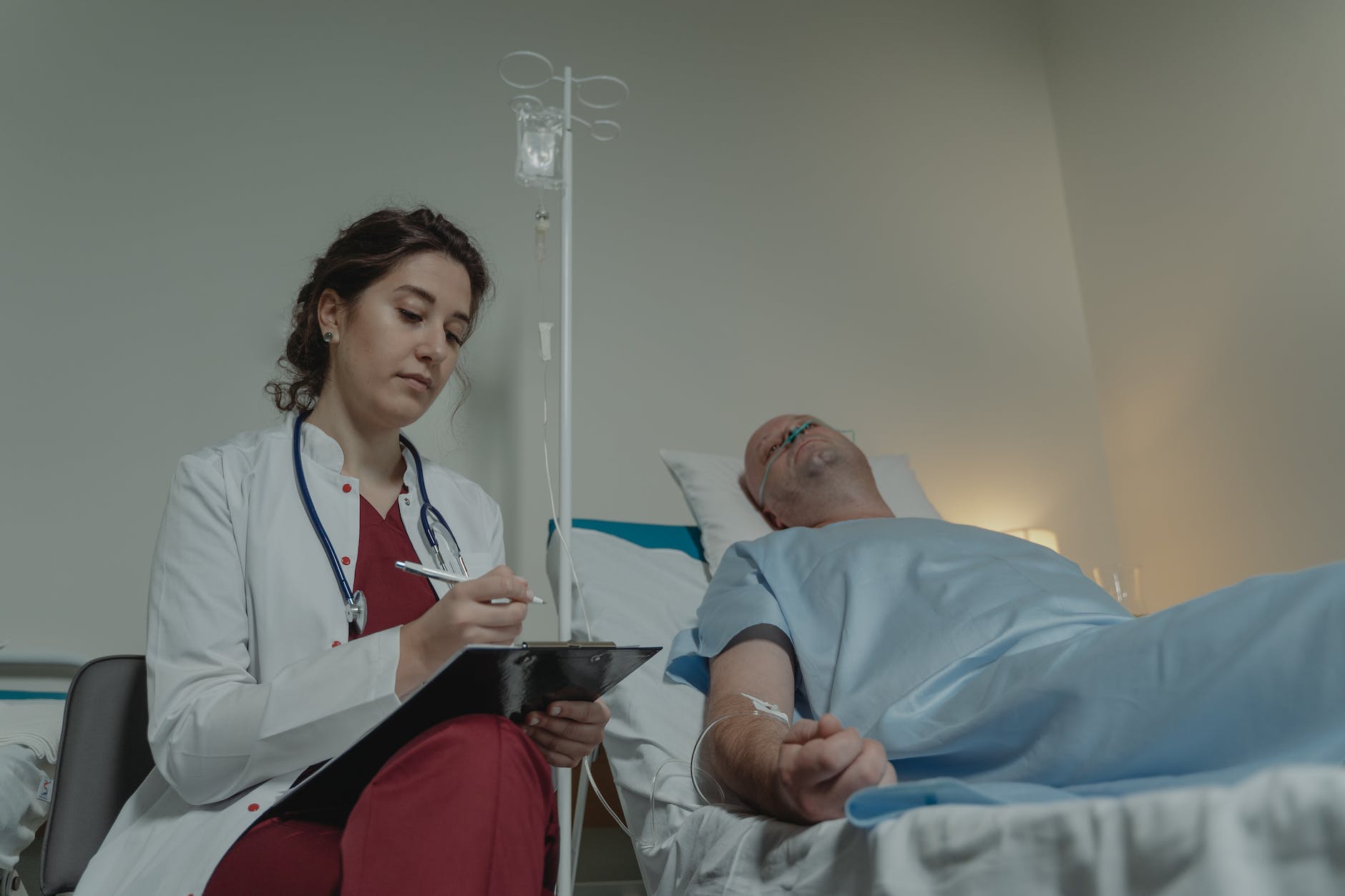 female doctor sitting bedside a patient