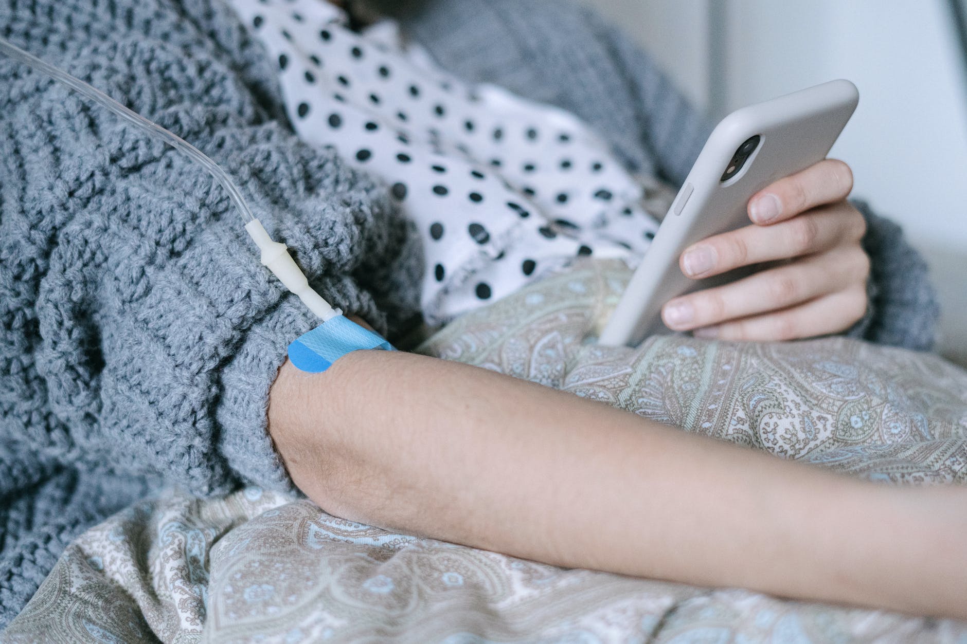 a patient using a phone while under infusion treatment