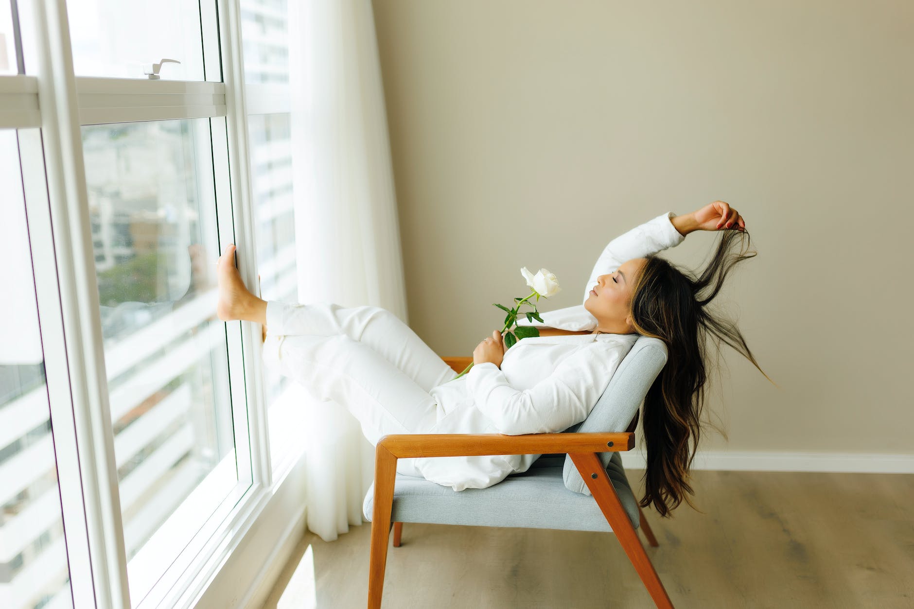 brunette relaxing with rose on chair