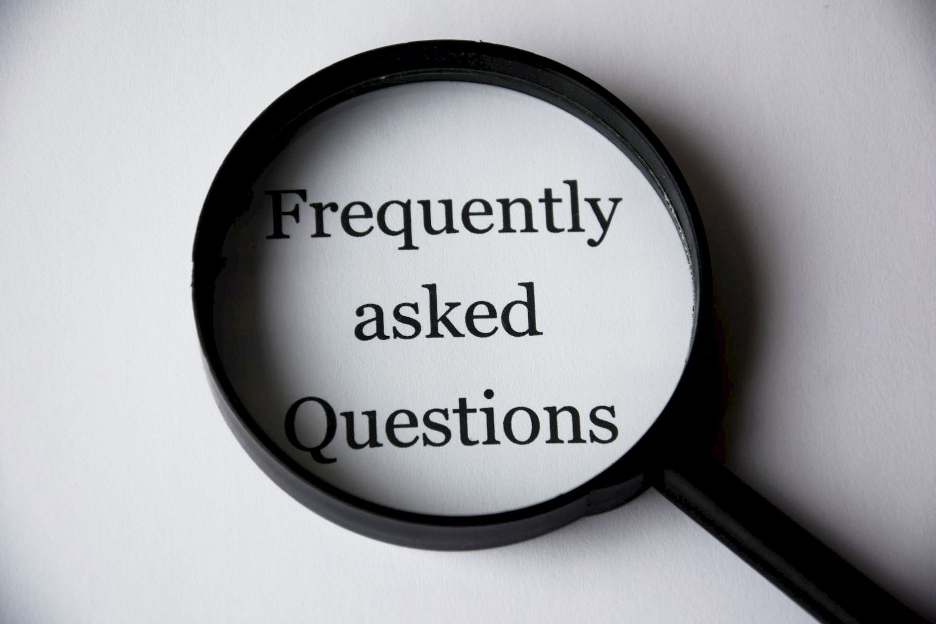 Magnifying glass over Frequently Asked Questions (FAQs) text