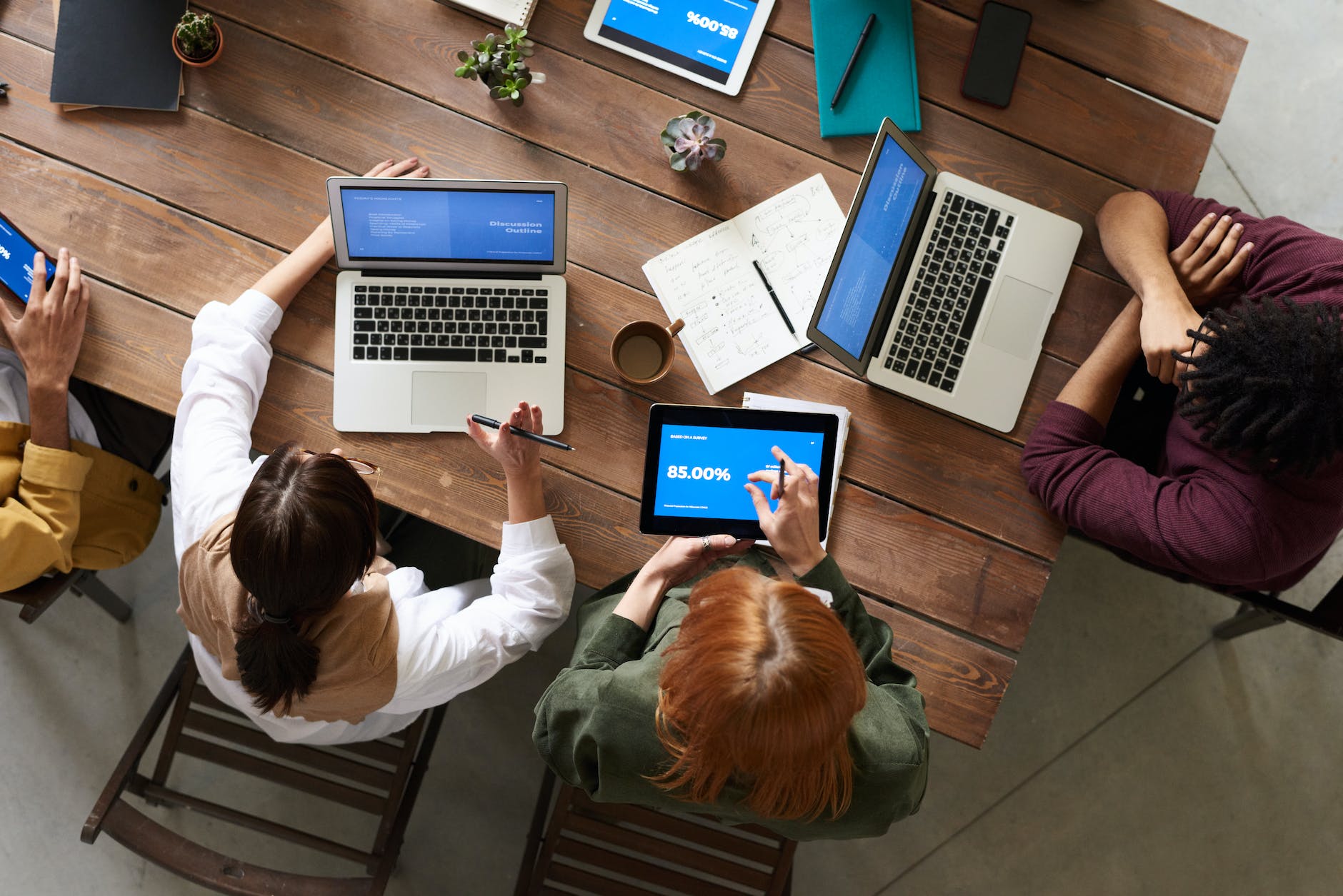 top down view of people at conference table with laptops