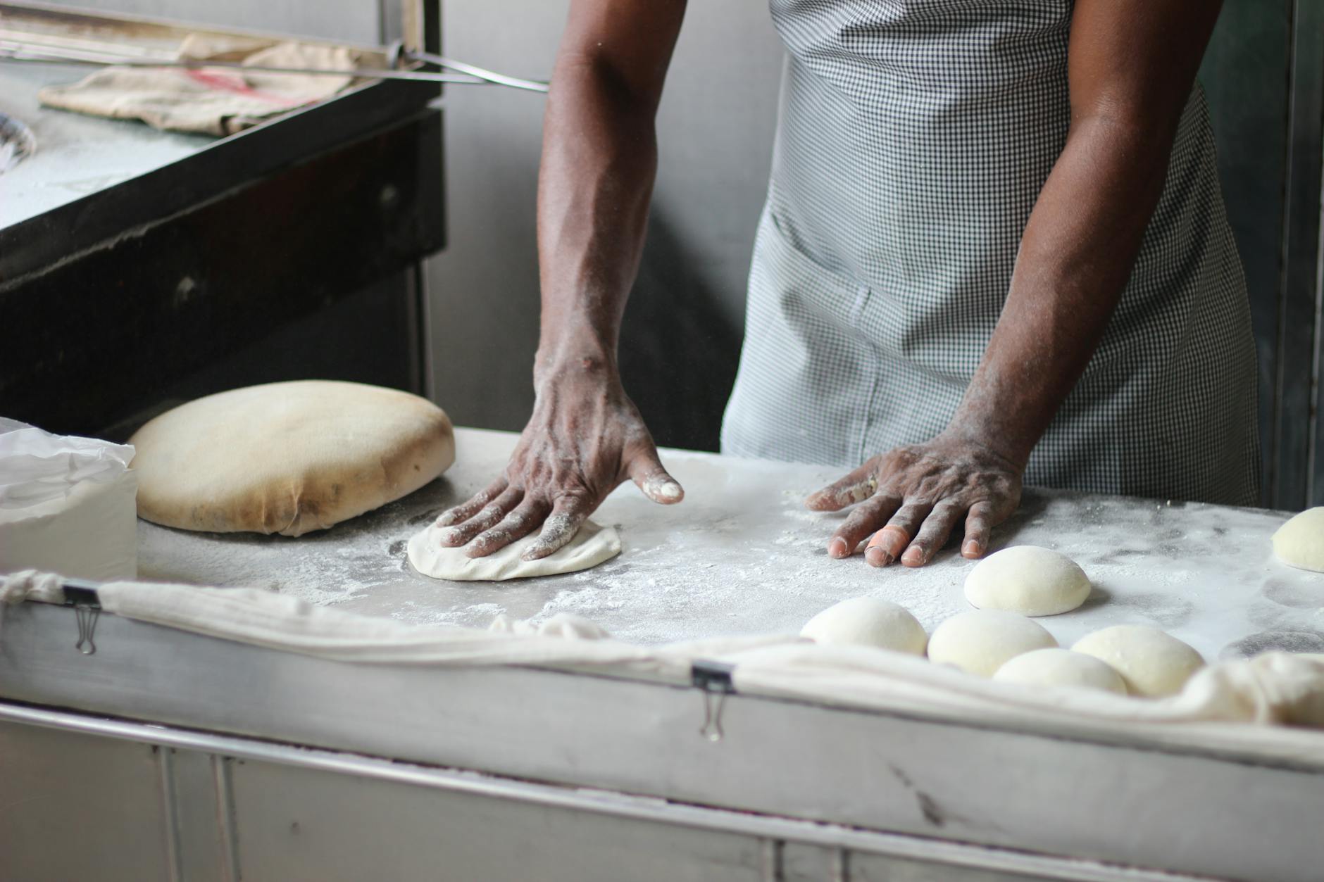 baker working with dough on counter