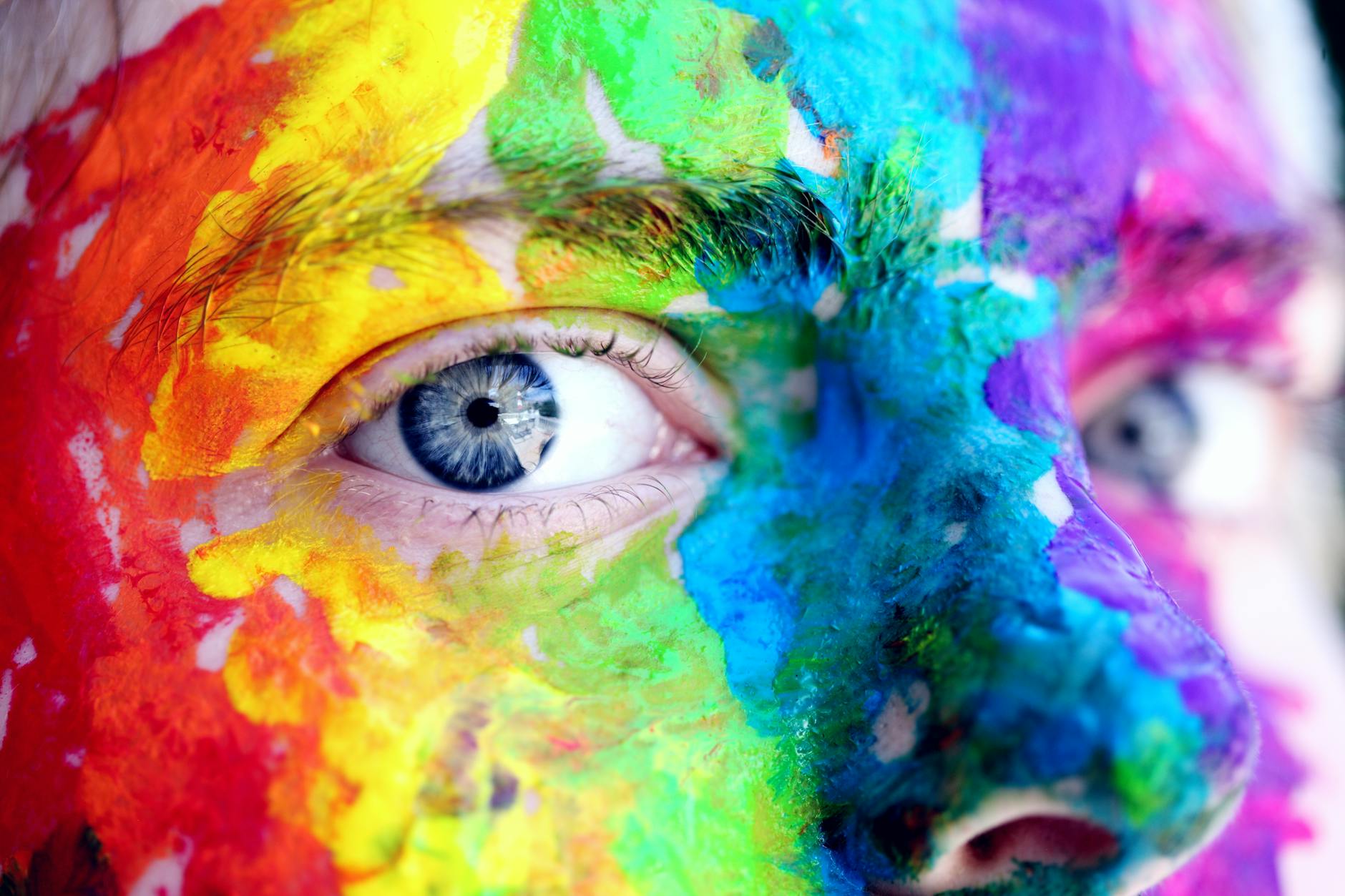 closeup of face painted with rainbow colors