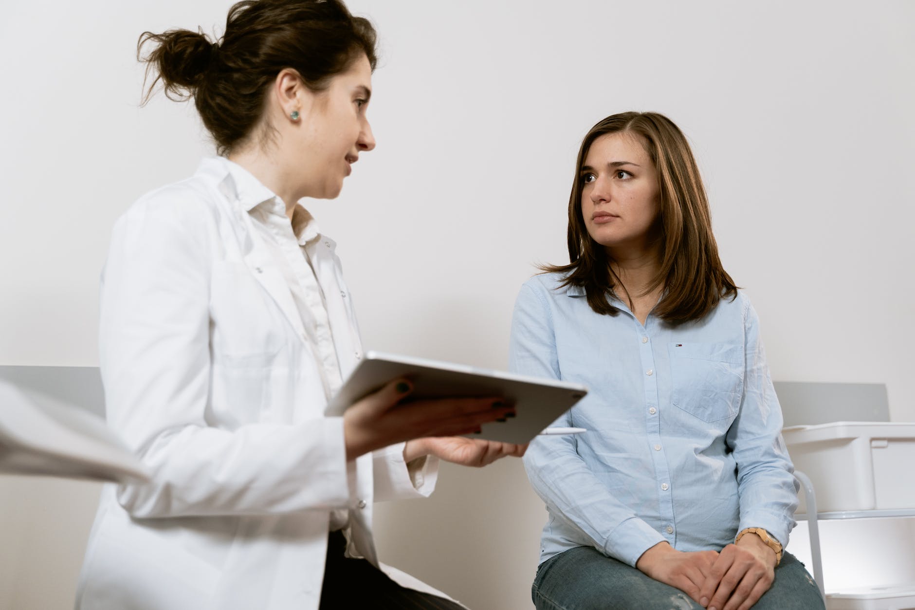 female clinician attending to seated female patient