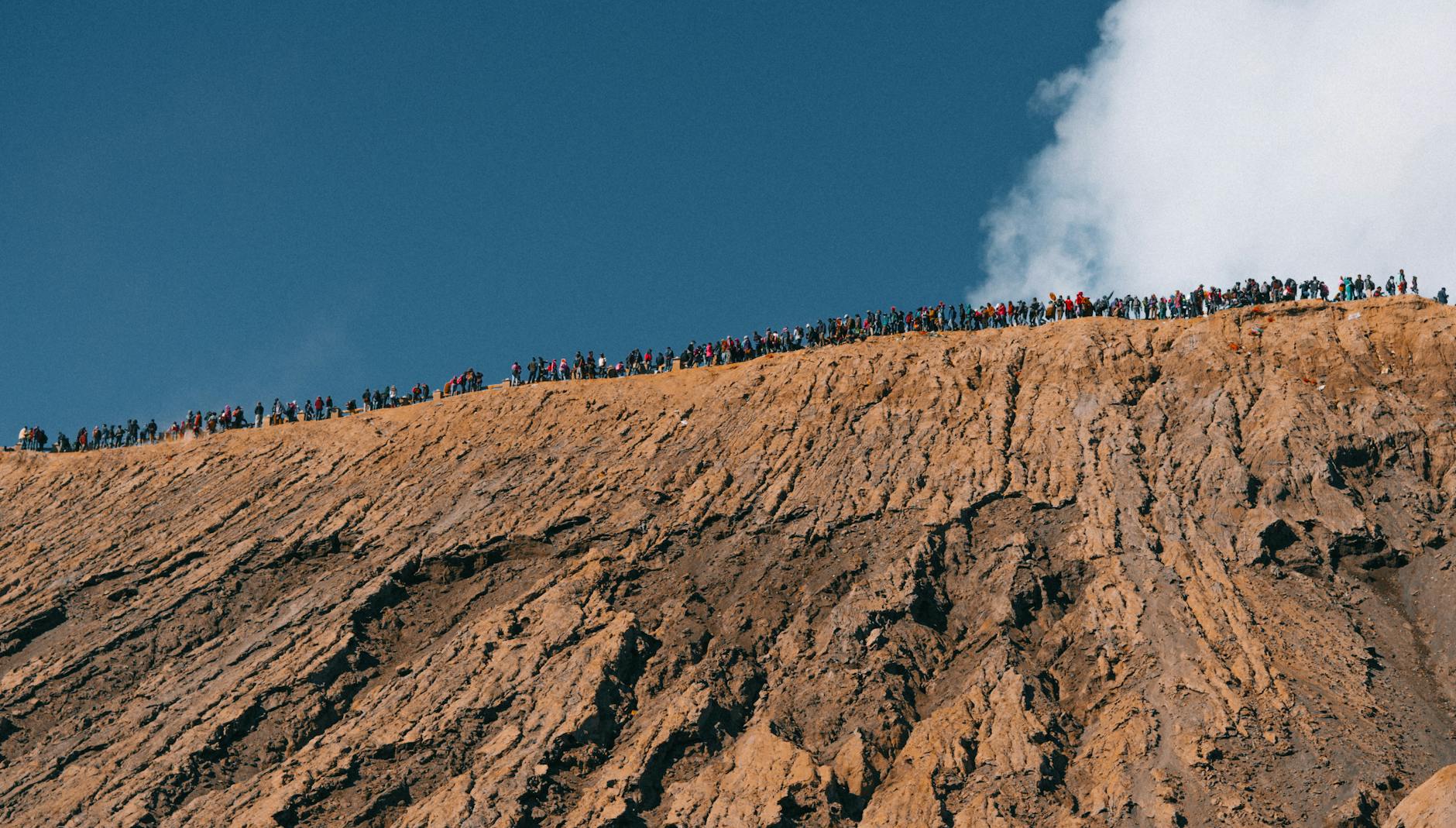 soil, hill, and dozens of people on top of the hill