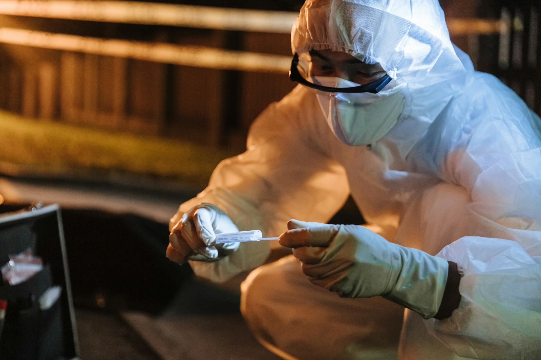 forensics technician obtaining sample from crime scene