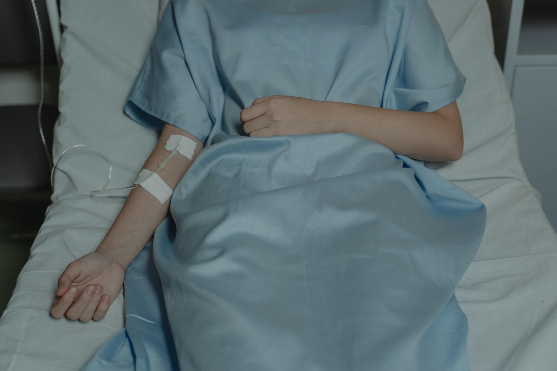 patient wearing blue robe and on hospital bed